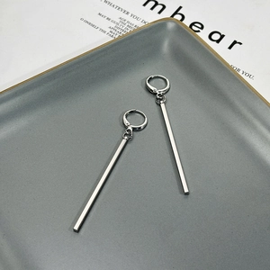 Minimalist silver long bar drop earrings with geometric line design on a ceramic tray