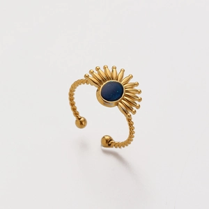 Close-up of golden twisted ring with blue oval stone and sunburst eye design