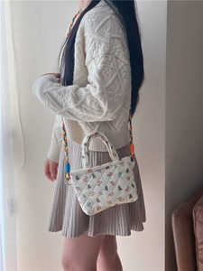 Close-up of quilted cotton crossbody bag with bear prints and colorful woven strap