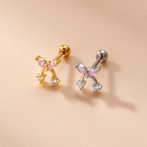 Detailed view of mini bow zircon stud earrings in gold and silver finish with pink gems