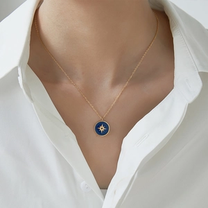 Gold 18K plated stainless steel necklace with blue enamel compass star pendant on a model