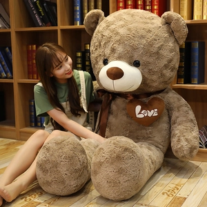 Detail of a giant brown teddy bear plush with silk bow and heart Love patch