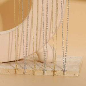 Detailed view of cross and lightning pendants with gold and silver zircon inlay