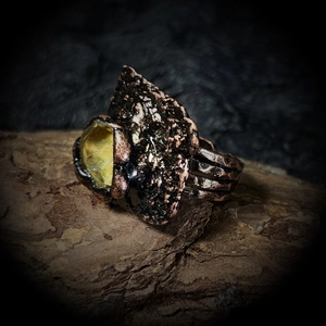 Vue macro d'une bague vintage en bronze avec texture martelée et pierre jaune