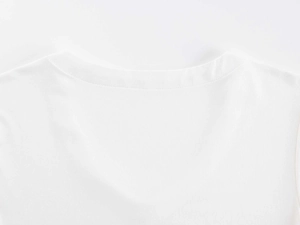 Close-up of the fine knit cotton texture and seamless stitching on the white V-neck collar