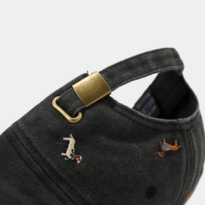 Close-up of washed cotton baseball cap with vintage bronze buckle and dog embroidery