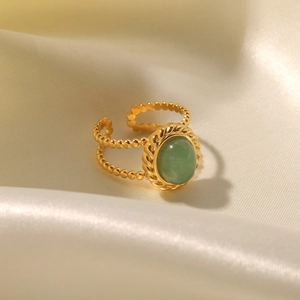 Close-up of a vintage gold double-beaded open ring with a round green natural stone inlay