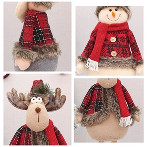 Detail of plush Christmas deer and snowman with red knit scarves and faux fur trim