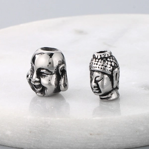 Macro shot of silver stainless steel laughing Buddha and Shakyamuni loose beads for jewelry