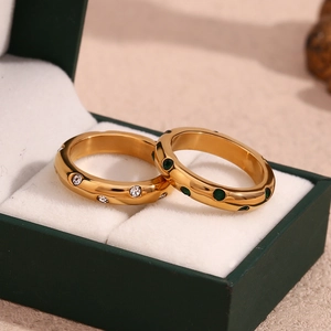 Detail von 18K vergoldeten Ringen mit grünen und klaren Zirkonia in einer Schmuckbox