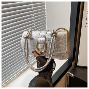 Close-up of silver crocodile pattern handbag with elegant gold U-shaped metal buckle