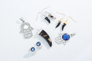 Détail à plat des breloques main de Hamsa avec cristaux bleus et pendentifs en corne