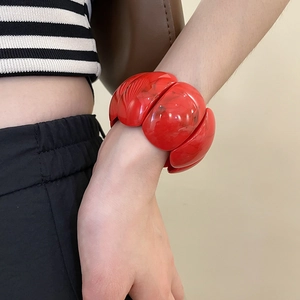 Close-up of red acrylic link bracelet with marble texture and chunky geometric design