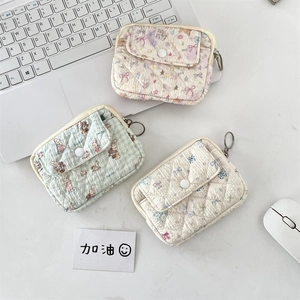 Quilted cotton card holder with zipper closure and snap pocket in a workspace setting