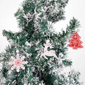 Close-up of wooden Christmas tree ornaments featuring reindeer and snowflake patterns
