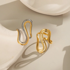 Irregular geometric 18K gold titanium rings displayed on a minimalist artistic tray