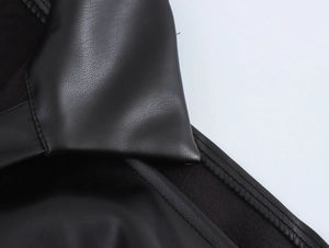 Detailed macro view of the black faux leather collar and shoulder texture on a biker dress