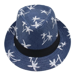 Detail of navy blue straw fedora hat featuring white palm tree prints and black ribbon band