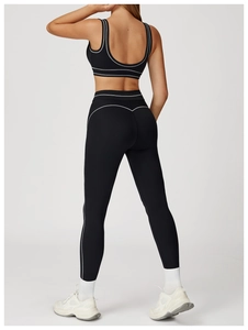 Detail of high-waisted black yoga pants with white double stripes and back stitching
