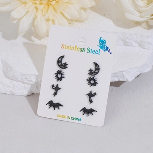Close-up of four pairs of black stainless steel studs in star, sun and moon shapes