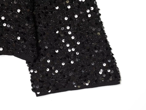 Detailed macro view of dense black sequins and knitting on a stylish fashion jacket
