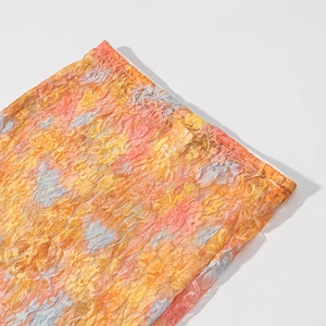 Close-up of orange floral lace mesh fabric detail with semi-sheer abstract pattern