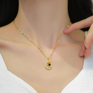 Elegant gold crescent moon necklace featuring white zircons and a black projection stone