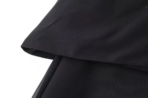 Detailed close-up showing black woven fabric layered with translucent mesh material