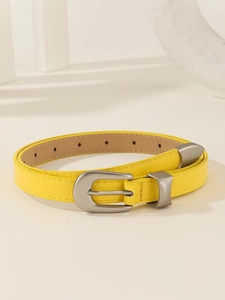 Detail of bright yellow leather belt with silver buckle and adjustment holes on ivory background