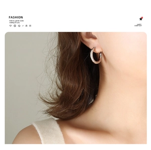 Close-up of a silver-colored 18K gold plated hoop earring on model with polished finish