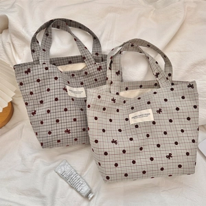 Gros plan de sacs à lunch en toile avec motifs à carreaux et détails de nœuds