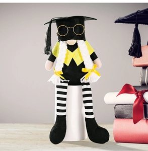Detail of graduation gnome plush with black mortarboard, glasses, and braided hair