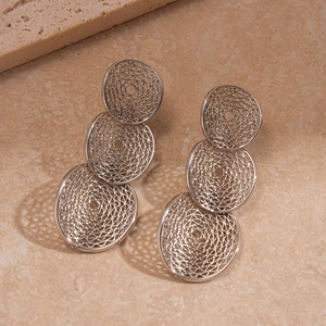 Macro detail of silver-tone metal mesh earrings with a triple-circle hollow design