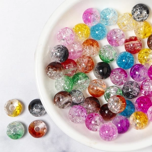 Assorted colorful cracked glass crystal beads for DIY jewelry making in a white ceramic bowl
