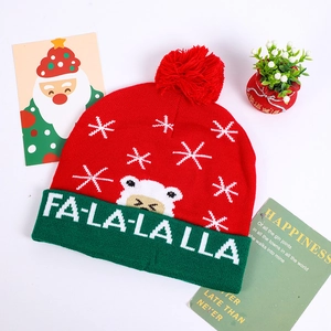Detailed view of red knitted Christmas LED hat featuring FA-LA-LA-LA text and snowflake patterns