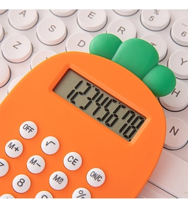 Macro detail of carrot-shaped calculator with orange and green body on white keyboard