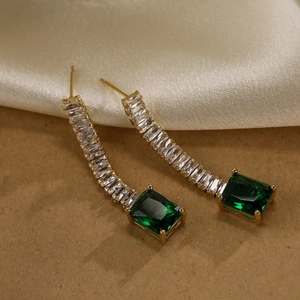 Luxurious gold-plated tassel earrings with green square stone on textured fabric