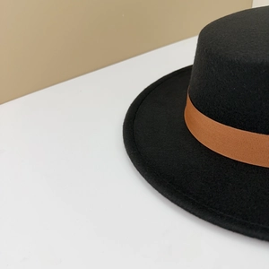Close-up of black wool felt boater hat with a premium brown grosgrain ribbon detail