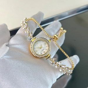 Macro detail of gold watch with leaf-shaped diamond strap and adjustable slide buckle