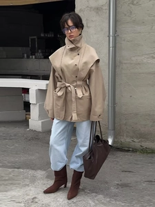Détail du trench-coat kaki avec grand revers et ceinture nouée en milieu urbain