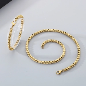 Detail view of gold stainless steel necklace and bracelet set with square box chain