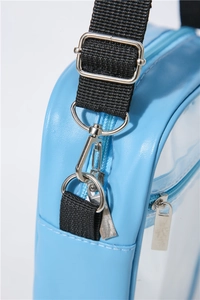 Macro detail of silver-tone metal buckle and blue leather trim on transparent PVC bag