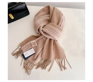 Detailed close-up of 100% Australian wool scarf featuring tassels and linear stitching