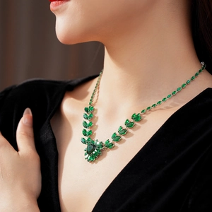 Close-up of necklace with marquise and pear-cut green gemstones on silver base
