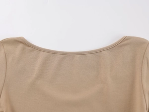 Detailed macro view of the U-neckline and fine knitted texture on khaki bodysuit