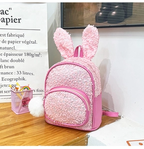 Detail of pink sequin toddler backpack with cute rabbit ears and white plush pompom