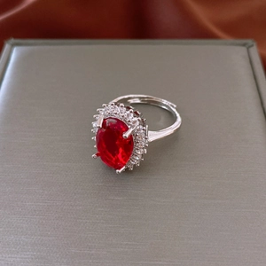 Macro detail of vintage oval red zircon ring with white cubic zirconia pavé setting