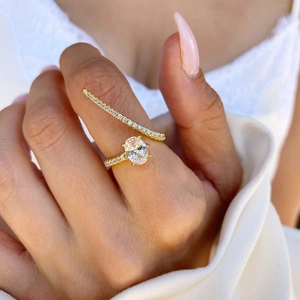 Elegant gold-plated four-claw bridal ring with oval crystal and pavé set cubic zirconia