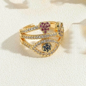 Detail of gold evil eye open ring with red heart zircon and multilayer pavé diamonds