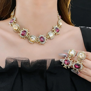 Detail of vintage gold jewelry set with yellow and purple gemstones on black mesh fabric